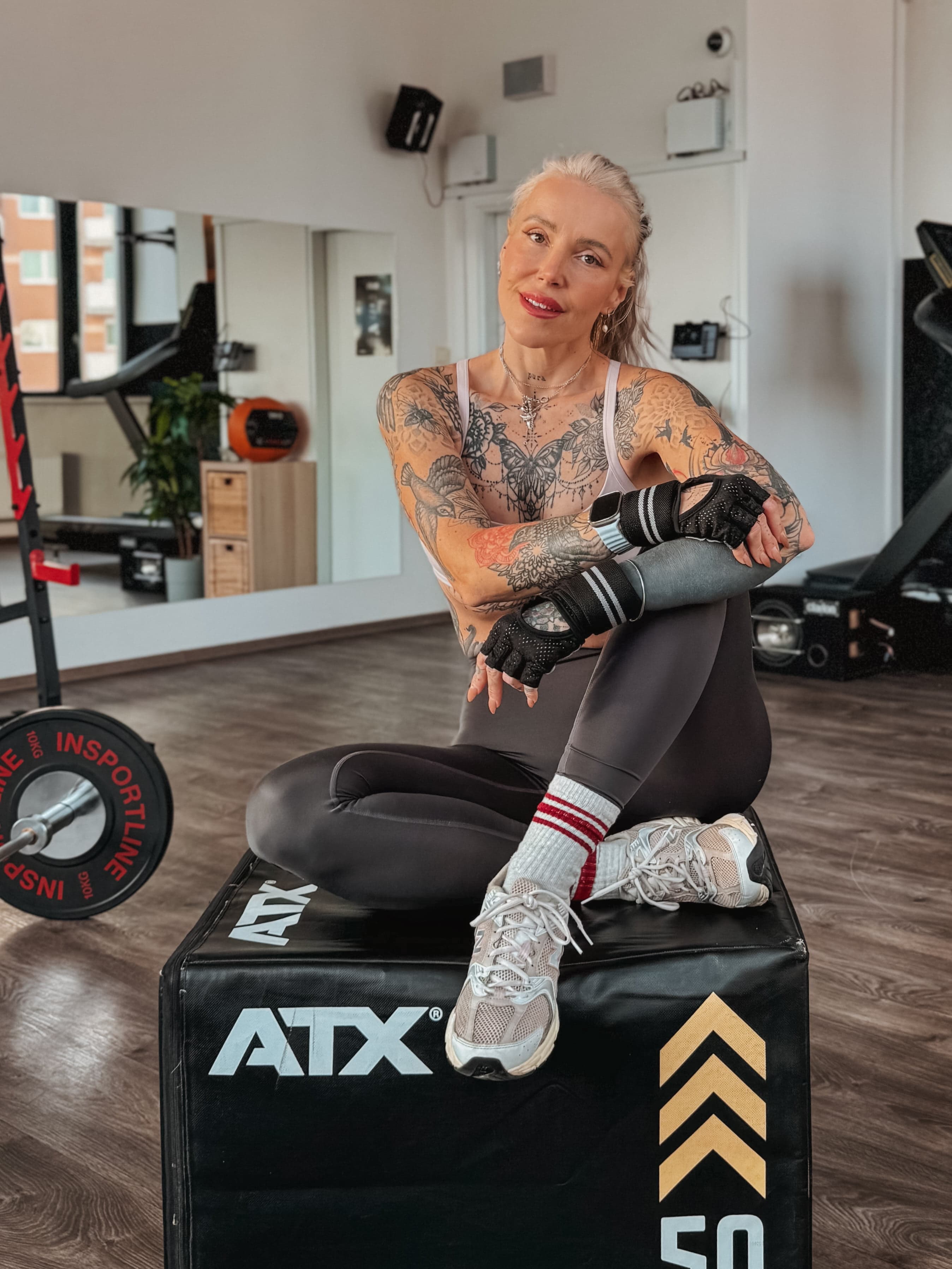 Nika v posilovně sedí na tréninkovém boxu